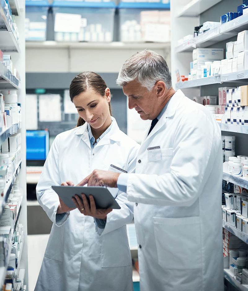 Pharmacists working on an iPad together within a pharmacy